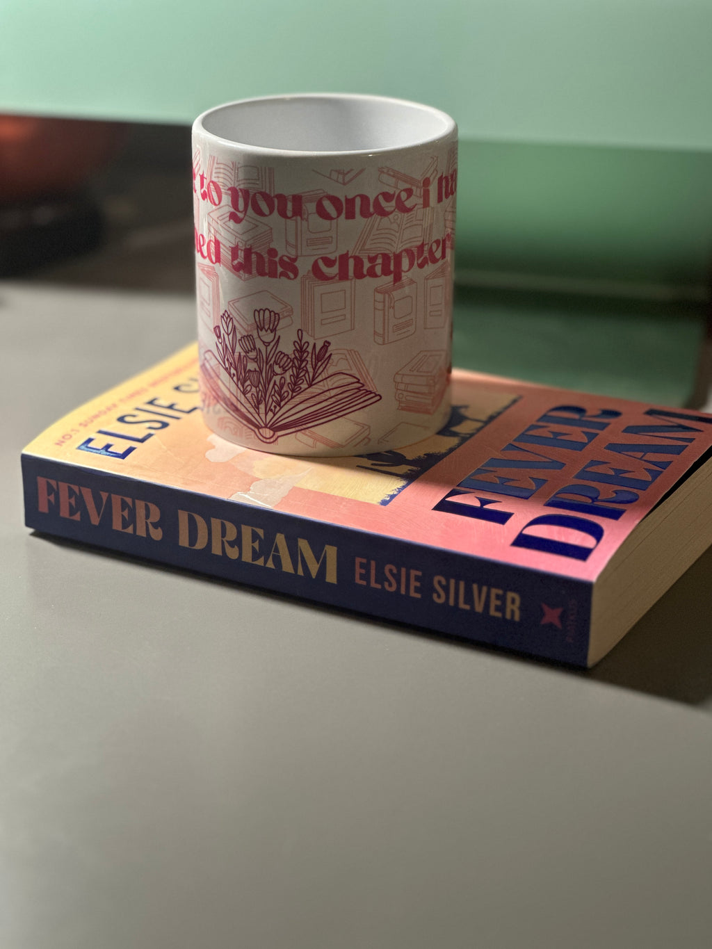 Front view of the I'll Speak To You Once I've Finished This Chapter mug on a book, showing tulip illustration