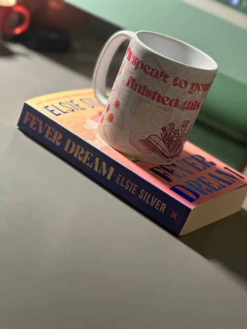 Bookish mug resting on Fever Dream by Elsie Silver, showing the quote wrap-around print with pink text and floral illustrations
