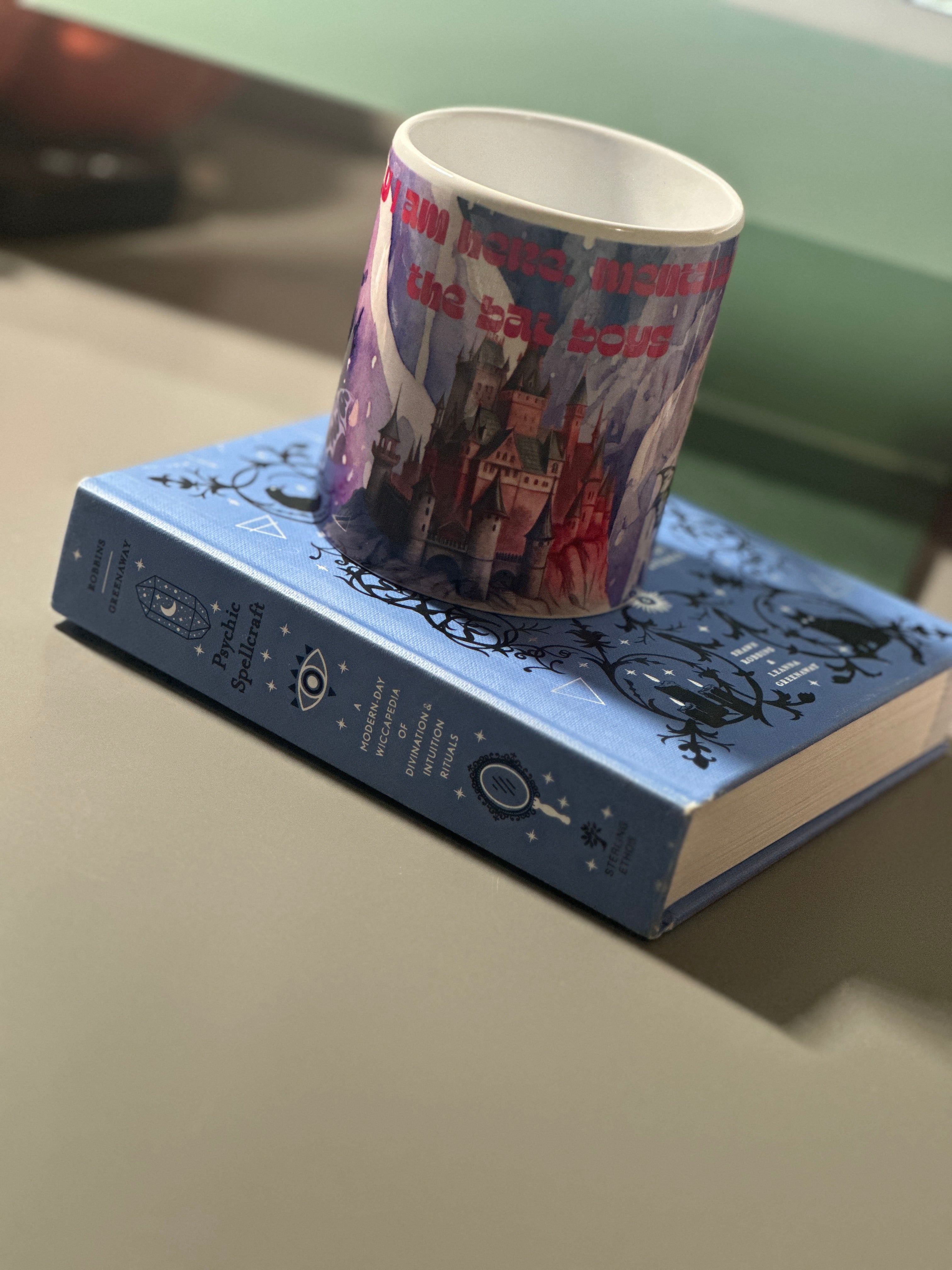 Angled view of the Bat Boys mug showing the castle illustration and bold red quote text on a deep purple background