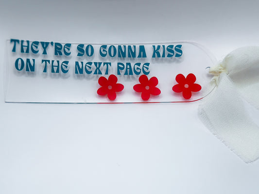 They're So Gonna Kiss on the Next Page acrylic bookmark with teal text and red flower details